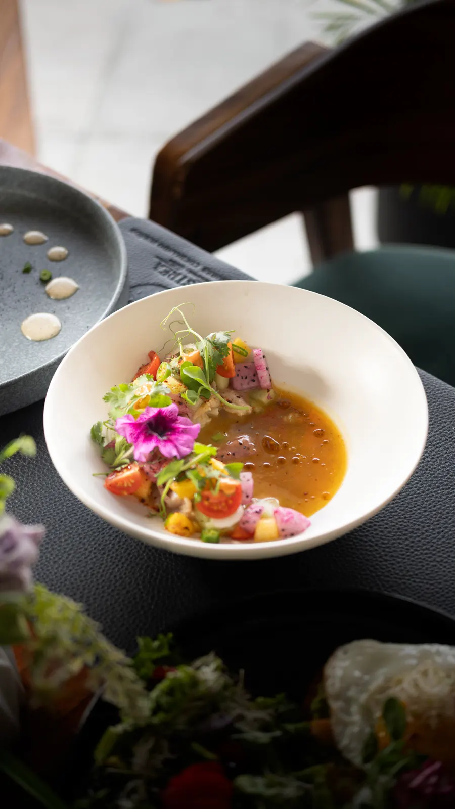 Plato hondo con ceviche y una flor comestible